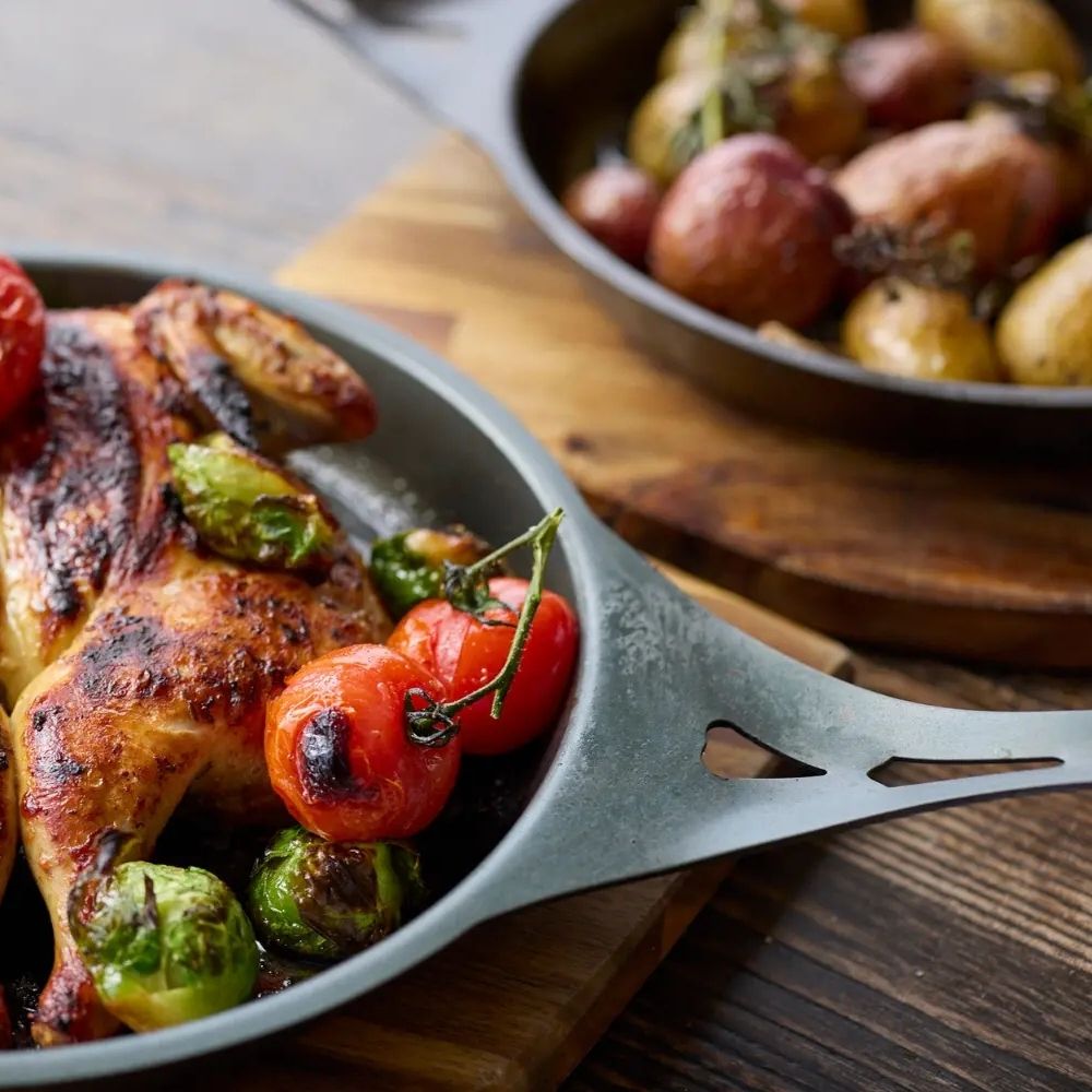 To AUS-ION jernpanner fra Solidteknics i bruk med mat – laget i rent australsk jern uten belegg, med naturlig non-stick som blir bedre med bruk.