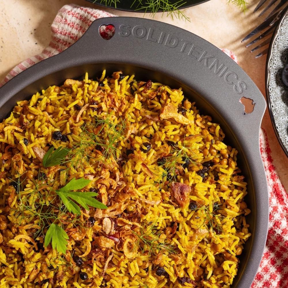 AUS-ION ovn til bord panne i jern fylt med hjemmelaget paella – naturlig non-stick, fri for belegg og laget i Australia for sunn og trygg matlaging.