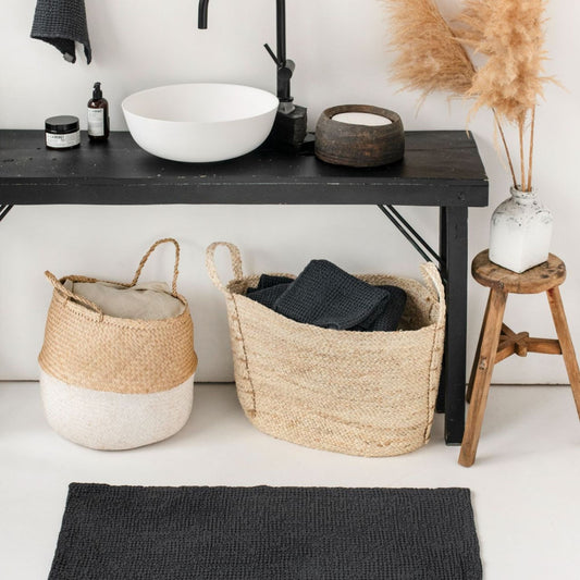 Bærekraftig badematte i mørk grå lin- og bomullsblanding liggende på lyst baderomsgulv