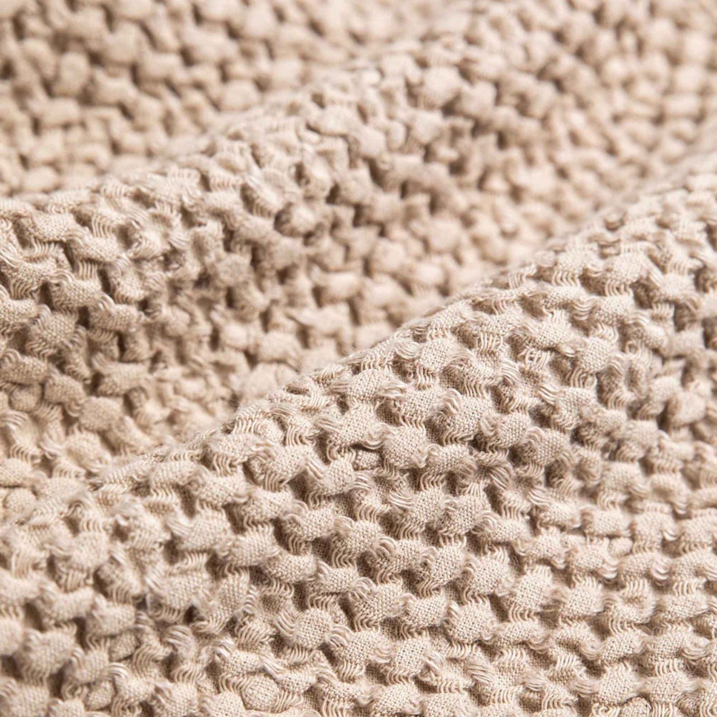 Nærbilde av vaffelstruktur i beige MagicLinen kjøkkenhåndkle i lin og bomull, hurtigtørkende og slitesterkt tekstil for bærekraftig kjøkkenbruk.