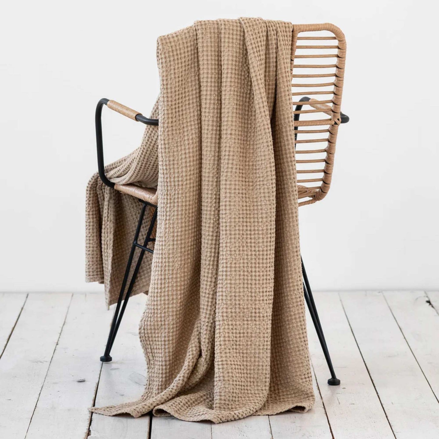 Beige pledd i lin og bomull lagt over stol, vaffelvevd og mykt, bærekraftig og allergivennlig, perfekt for et sunt hjem