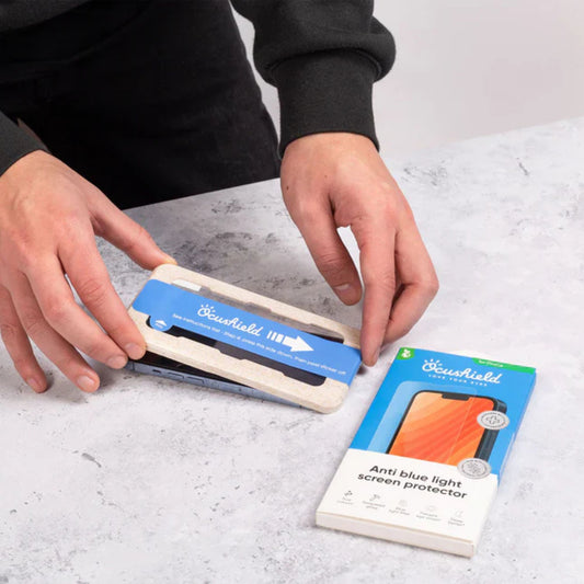 Mann som enkelt og presist påfører Ocushield skjermbeskytter med miljøvennlig, biologisk nedbrytbart påføringsbrett – boblefritt og stressfritt.