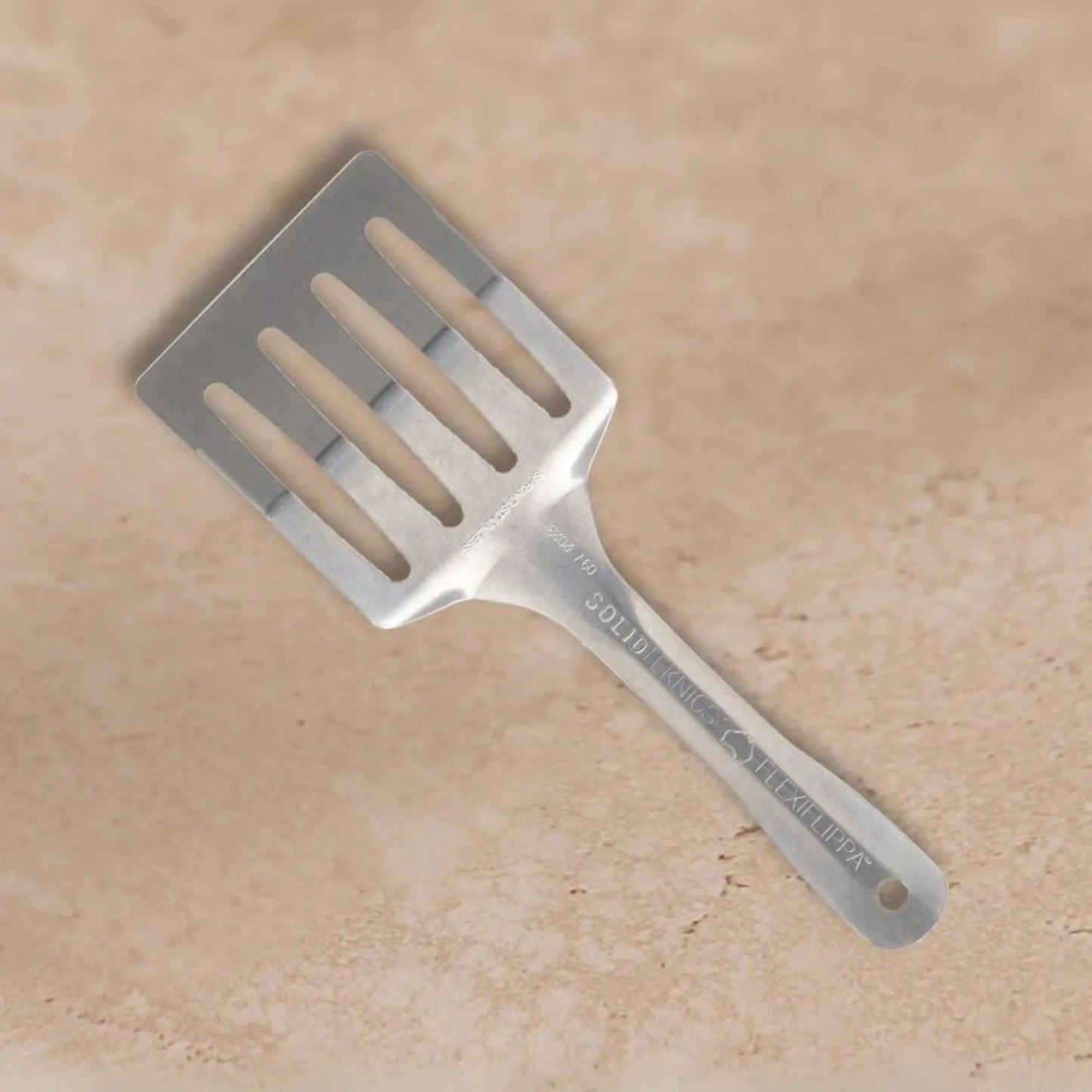 Flexi Flippa stekespade i nikkelfritt rustfritt stål fra Solidteknics. Plastfritt, fleksibelt og varig kjøkkenredskap laget for trygg og bærekraftig matlaging.