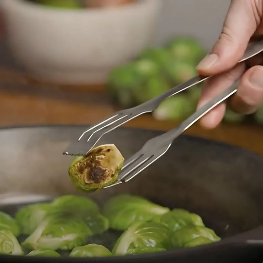 Lil Flippa kjøkkentang i rustfritt stål fra Solidteknics løfter grønnsaker i pannen. Plastfritt, varig og hygienisk kjøkkenredskap for trygg matlaging uten kjemikalier.