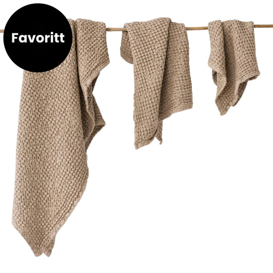 MagicLinen beige håndklesett i lin og bomull med tre håndklær og Favoritt-etikett, viser naturlige materialer, myk struktur og tidløst design for et sunnere hjem.