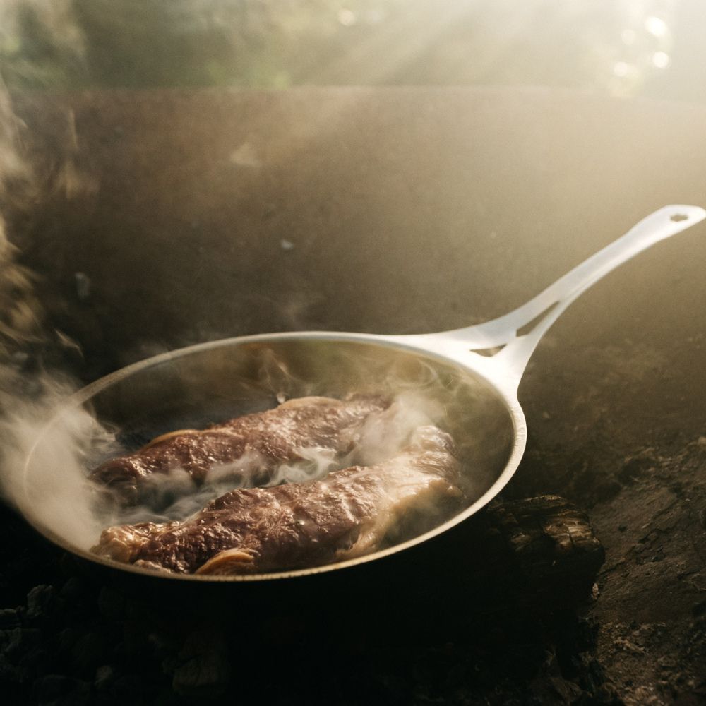 nöni nikkelfri stekepanne i rustfritt stål brukt til matlaging over åpen ild og bål, et trygt og slitesterkt alternativ uten belegg eller giftstoffer.