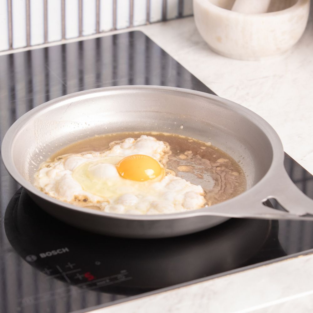 Nöni nikkelfri stekepanne i rustfritt stål brukt på stekeplate til å steke speilegg, fri for PFAS, teflon og giftige belegg.