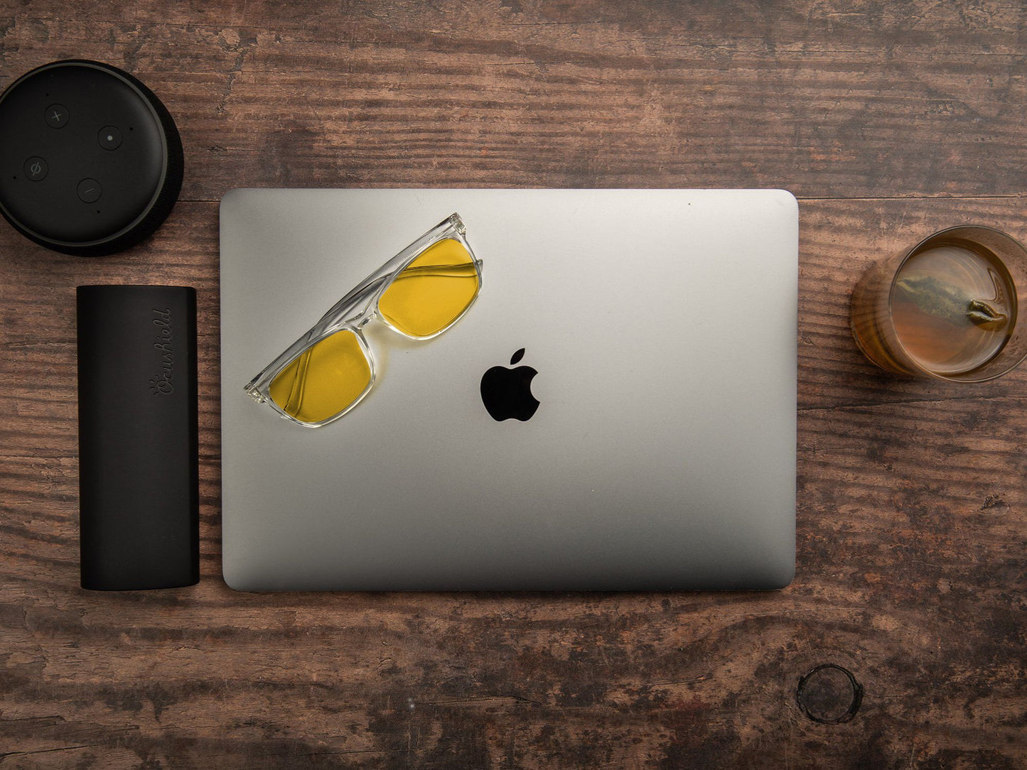 Ocushield Parker blålysbriller med klar innfatning og oransje glass for kveld, skjermbruk og bedre søvn, plassert på MacBook