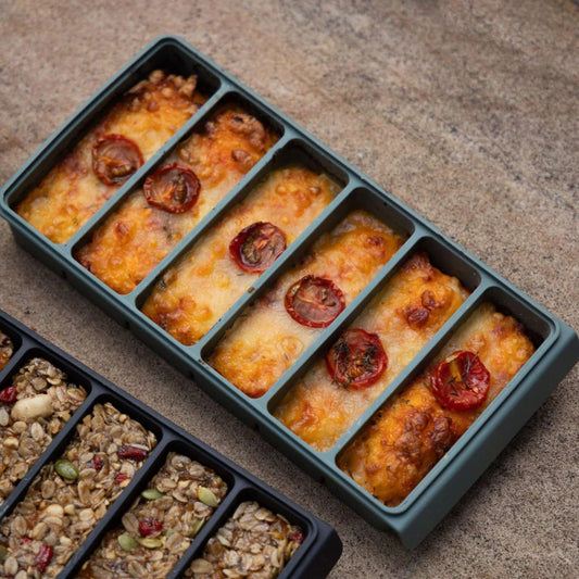 Silikon fryseform med seks porsjoner bakt mat på kjøkkenbenk.