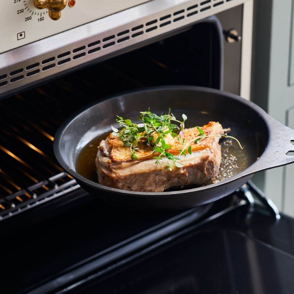Solidteknics AUS-ION jernpanne brukt på ulike varmekilder, fra induksjon og stekeovn til grill og bål, en slitesterk stekepanne som varer i generasjoner
