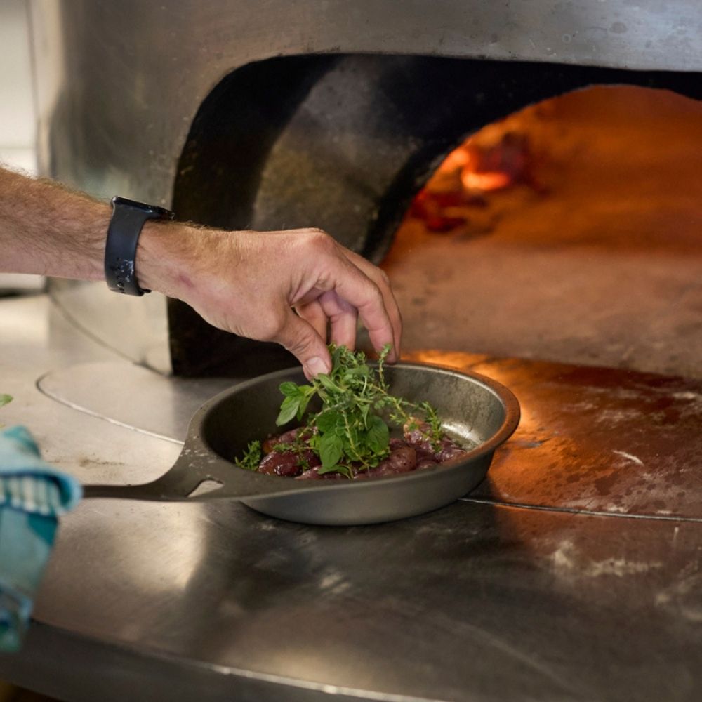 AUS-ION panne fra Solidteknics brukt i pizzaovn for steking på høy varme – viser hvor allsidig og robust pannen er.