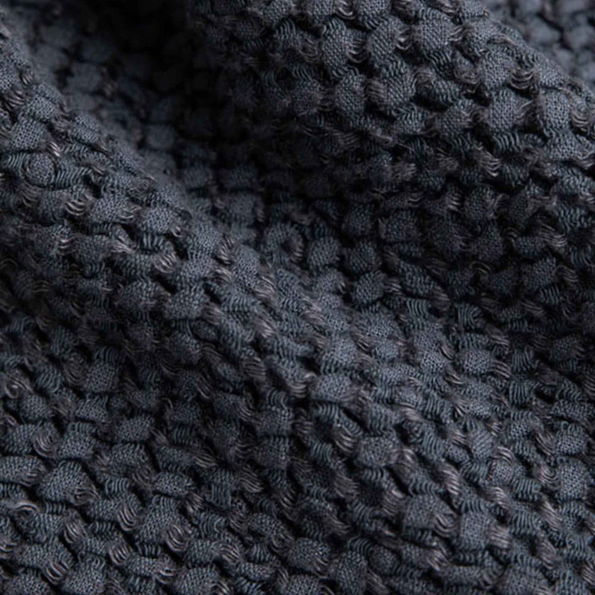 Nærbilde av vaffelstruktur i mørkegrått håndkle av lin og bomull fra MagicLinen, viser den luftige veven, naturlige teksturen og håndverkskvaliteten.