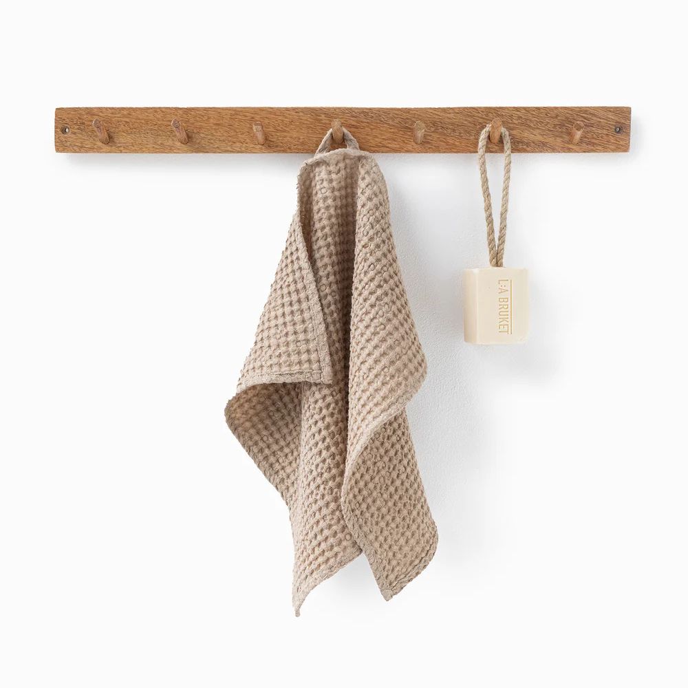 Beige waffle håndkle i lin og bomull henger på knagg, viser naturlig struktur, rask tørk og et rent, bærekraftig uttrykk.