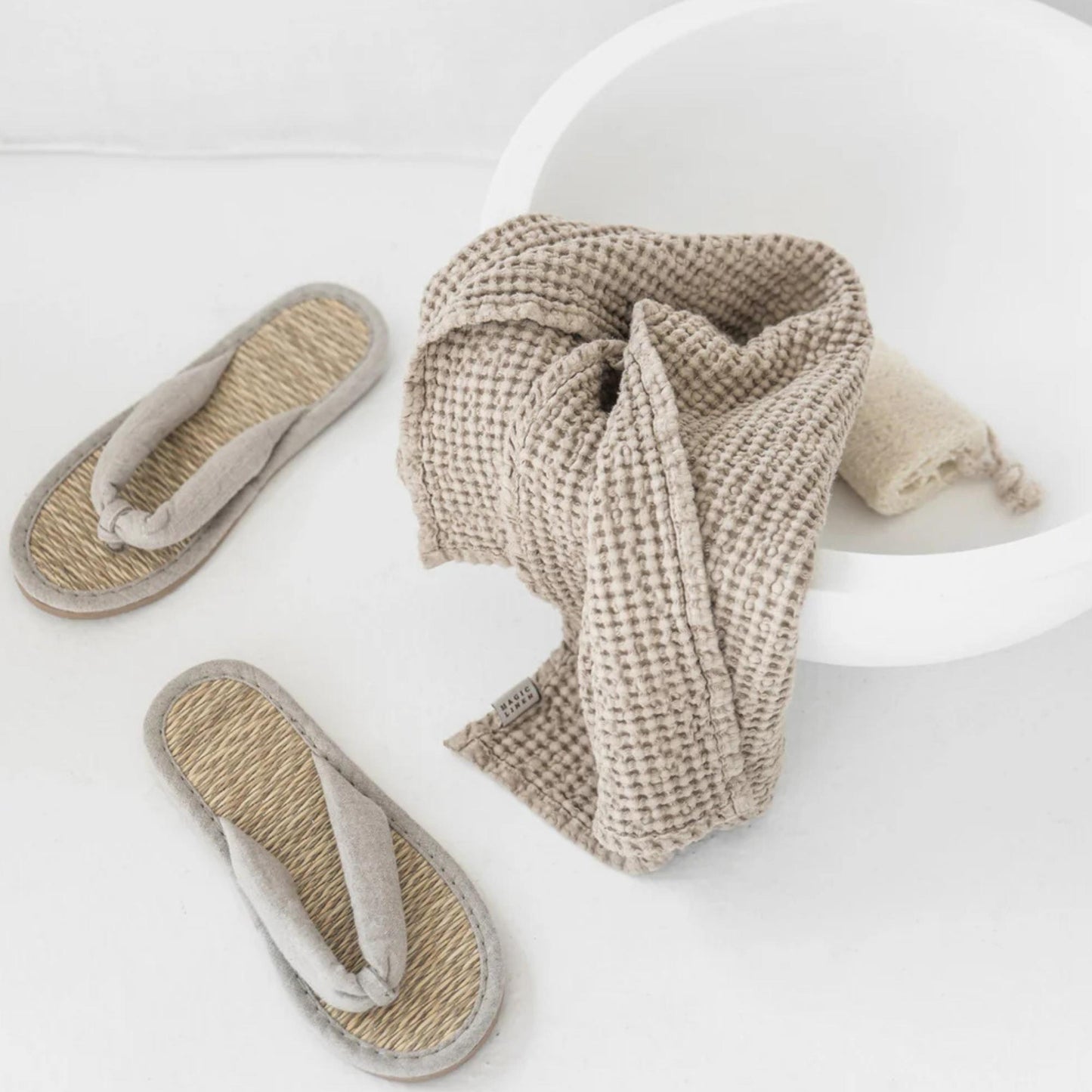 Naturlig beige håndkle i lin og bomull på vask, fremhever trygge materialer uten kjemikalier og et sunnere hjemmemiljø.