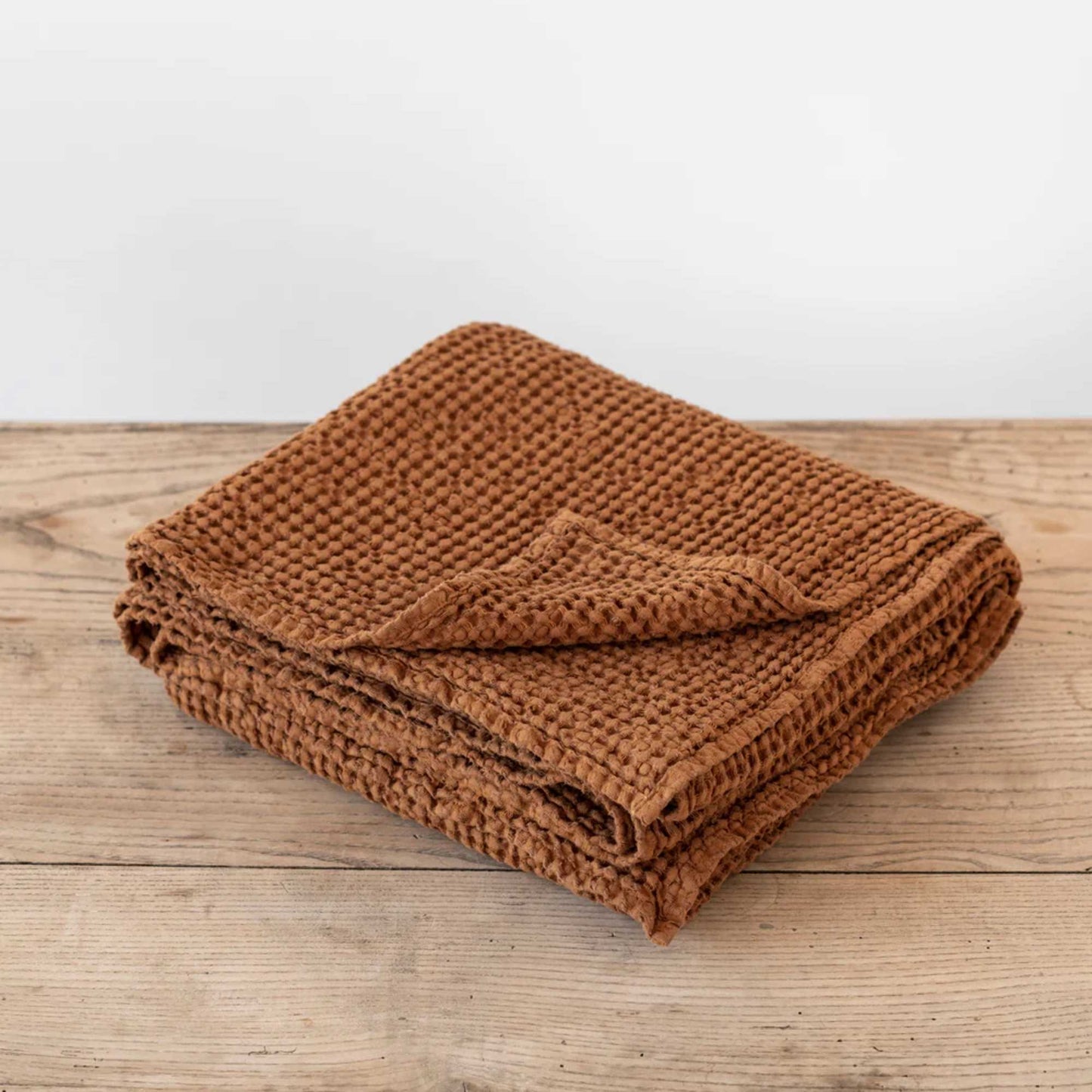 Brettet waffle-pledd i lin og bomull i fargen cinnamon fra MagicLinen, vist for å fremheve tekstur og naturlige materialer.