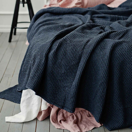 Mørkegrå waffle sengeteppe i lin og bomull på seng – pustende og tidløst soveromstekstil