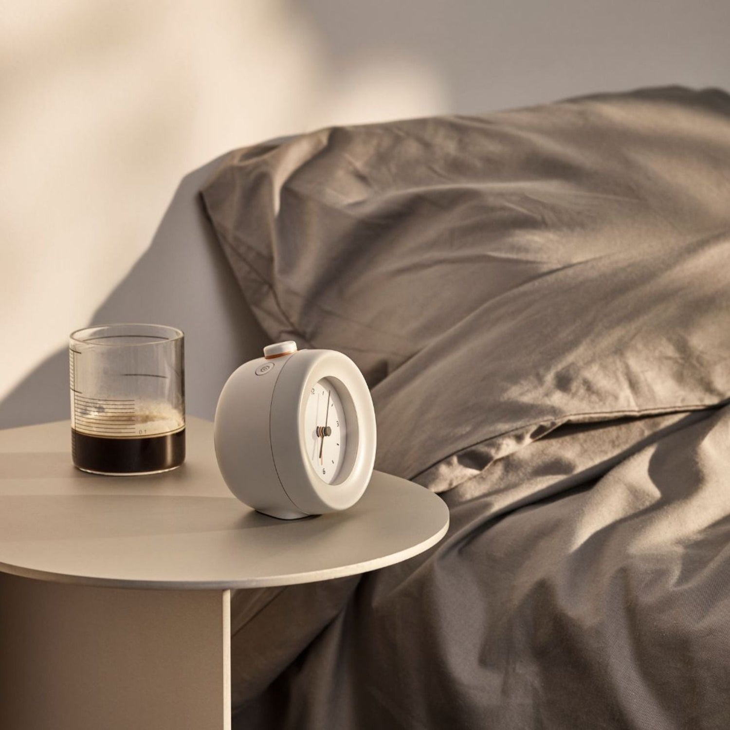 Sengetøy i lin på soverom ved siden av Mudita vekkerklokke