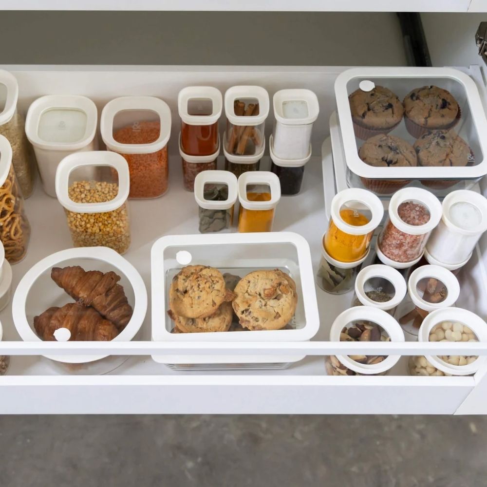 Flere glassbeholdere med glasslokk organisert i kjøkkenskuff – plastfritt og ryddig oppbevaringssystem fra Seed & Sprout.