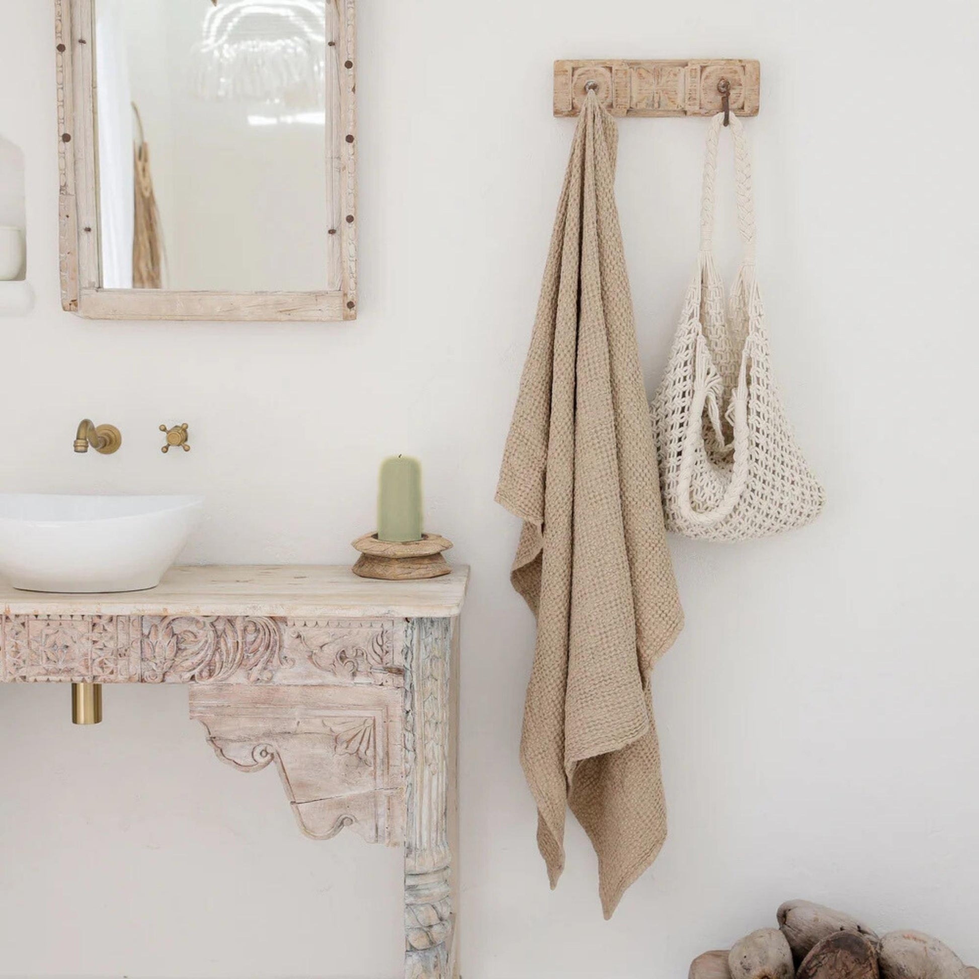 Beige badehåndkle i lin og bomull på et naturlig bad med grønt bivokslys og treinnredning, miljøvennlig og allergivennlig tekstil for et sunt hjem.