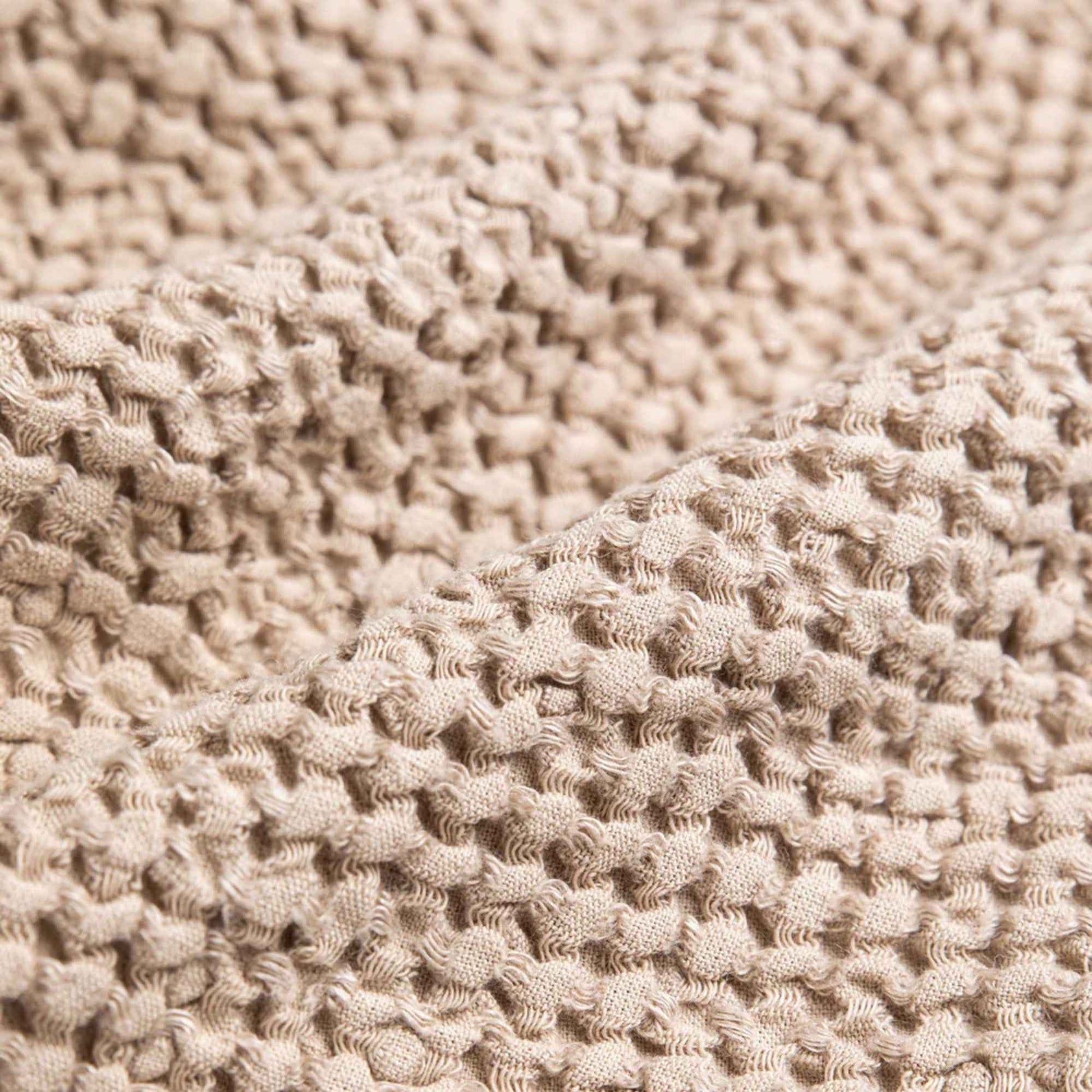 Nærbilde av vaffelstruktur i beige MagicLinen kjøkkenhåndkle i lin og bomull, hurtigtørkende og slitesterkt tekstil for bærekraftig kjøkkenbruk.
