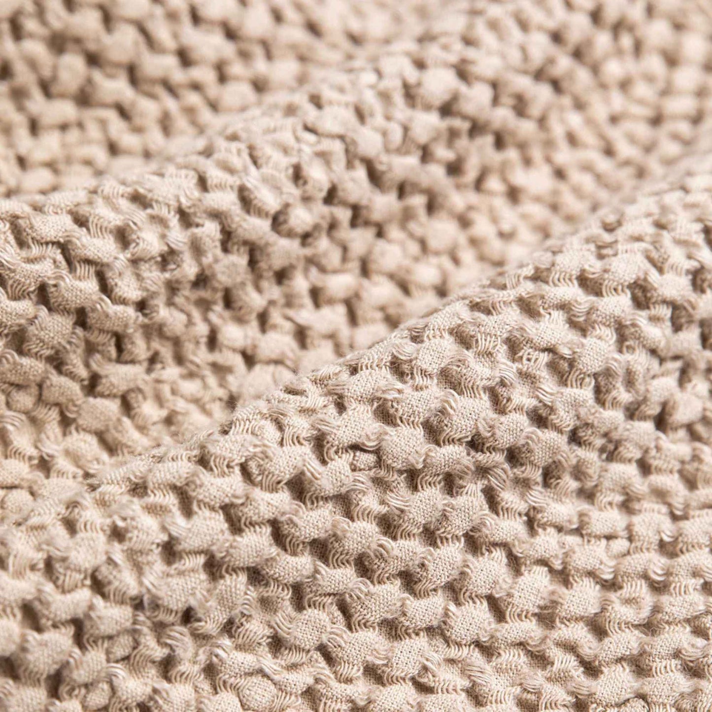 Vaffelvevd lin- og bomullspledd i beige, detaljbilde av tekstur og mykhet for et sunt hjem