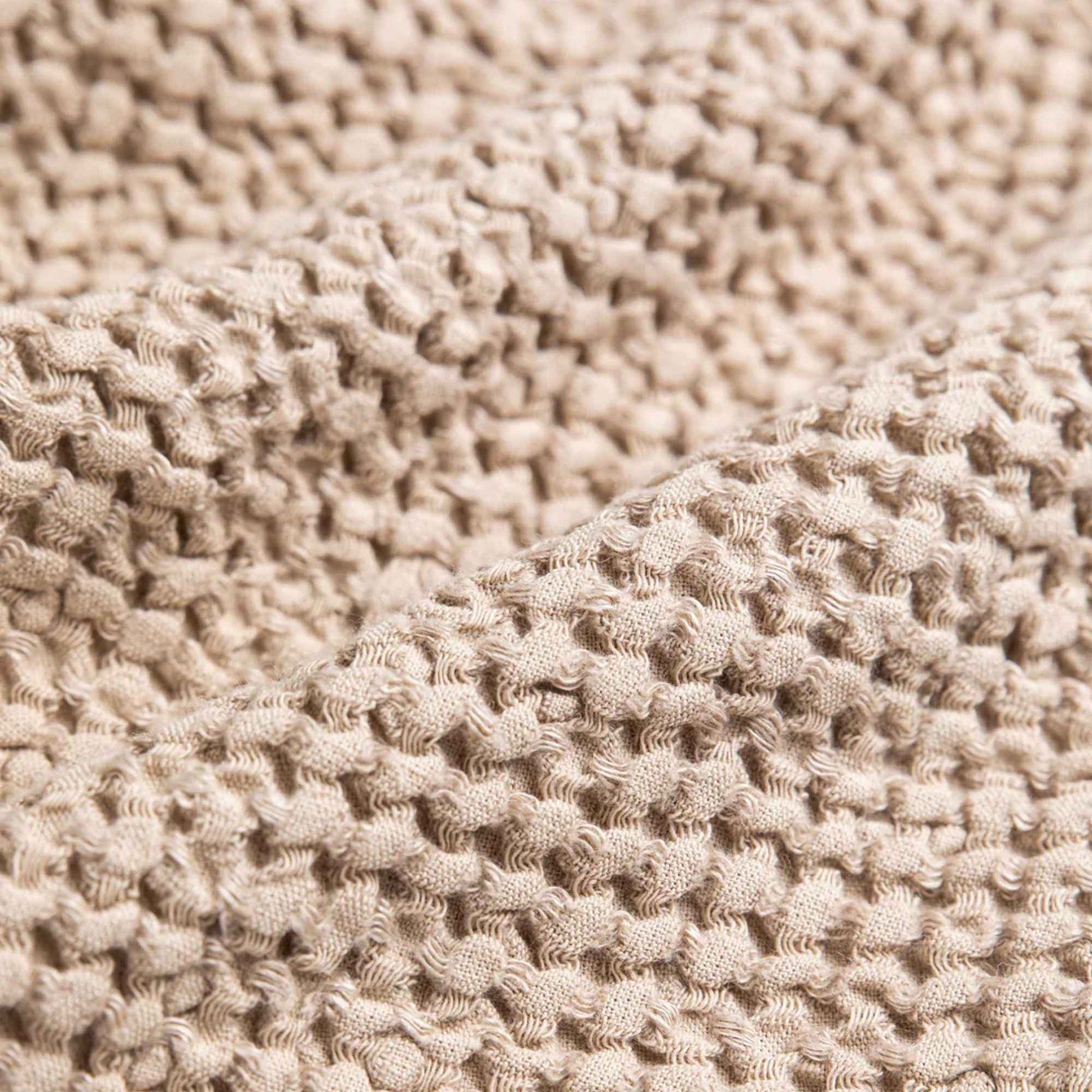 Vaffelvevd lin- og bomullspledd i beige, detaljbilde av tekstur og mykhet for et sunt hjem