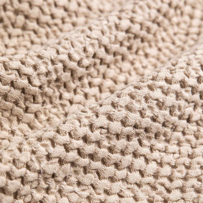 Vaffelvevd lin- og bomullspledd i beige, detaljbilde av tekstur og mykhet for et sunt hjem