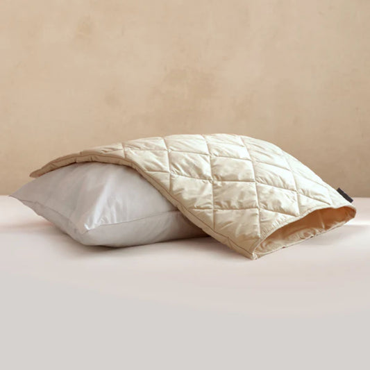 Vaskbar putebeskytter i ull og økologisk bomull lagt over pute – pustende og naturlig beskyttelse for bedre søvn