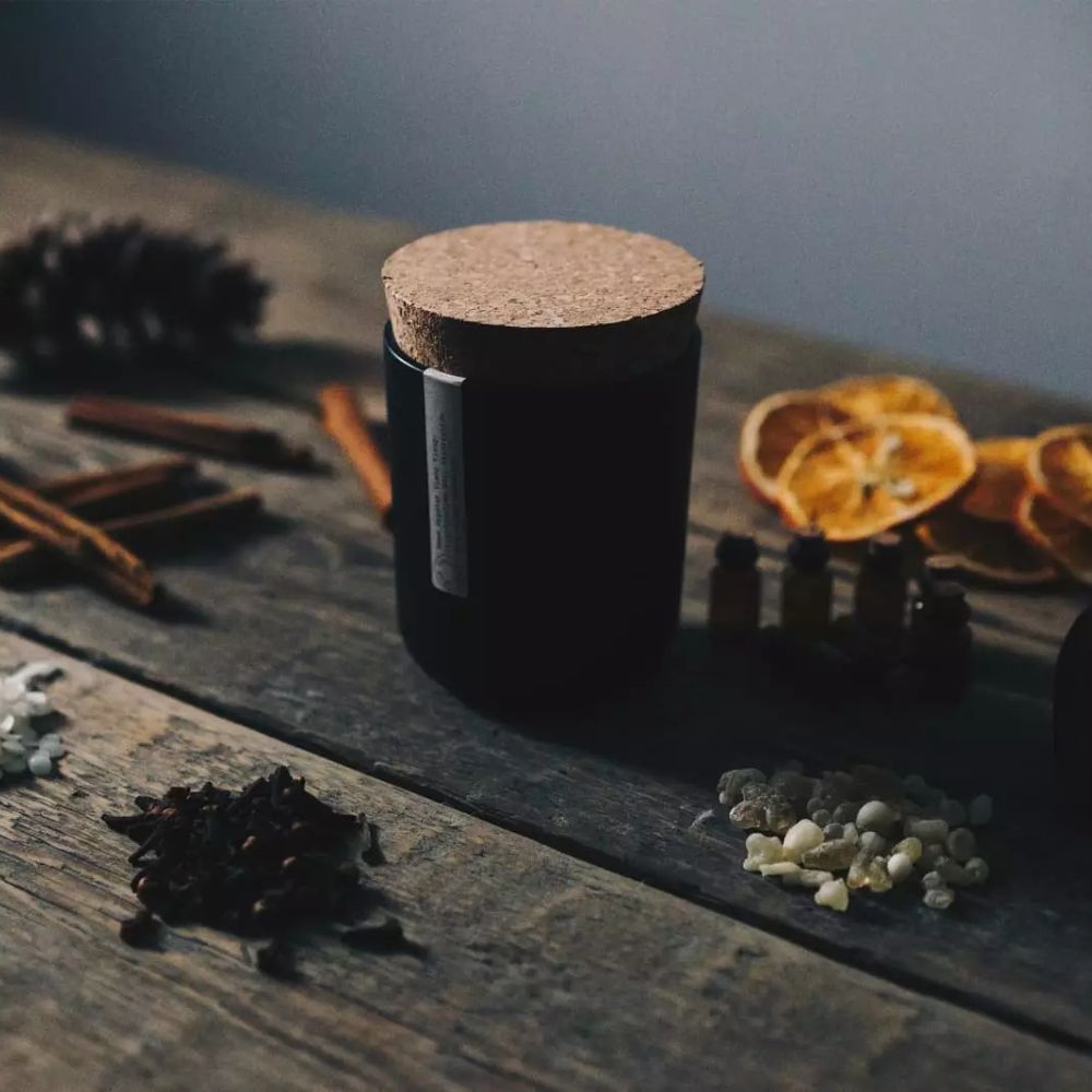 Duftlys med økologisk appelsin, kanel, røkelse (frankincense) og nellik som ingredienser, omgitt av appelsinskall, kanelstenger, røkelsesharpiks og nellikspiker. Et vakkert vinterinspirert aromaterapilys, 100 % sertifisert økologisk i Storbritannia.