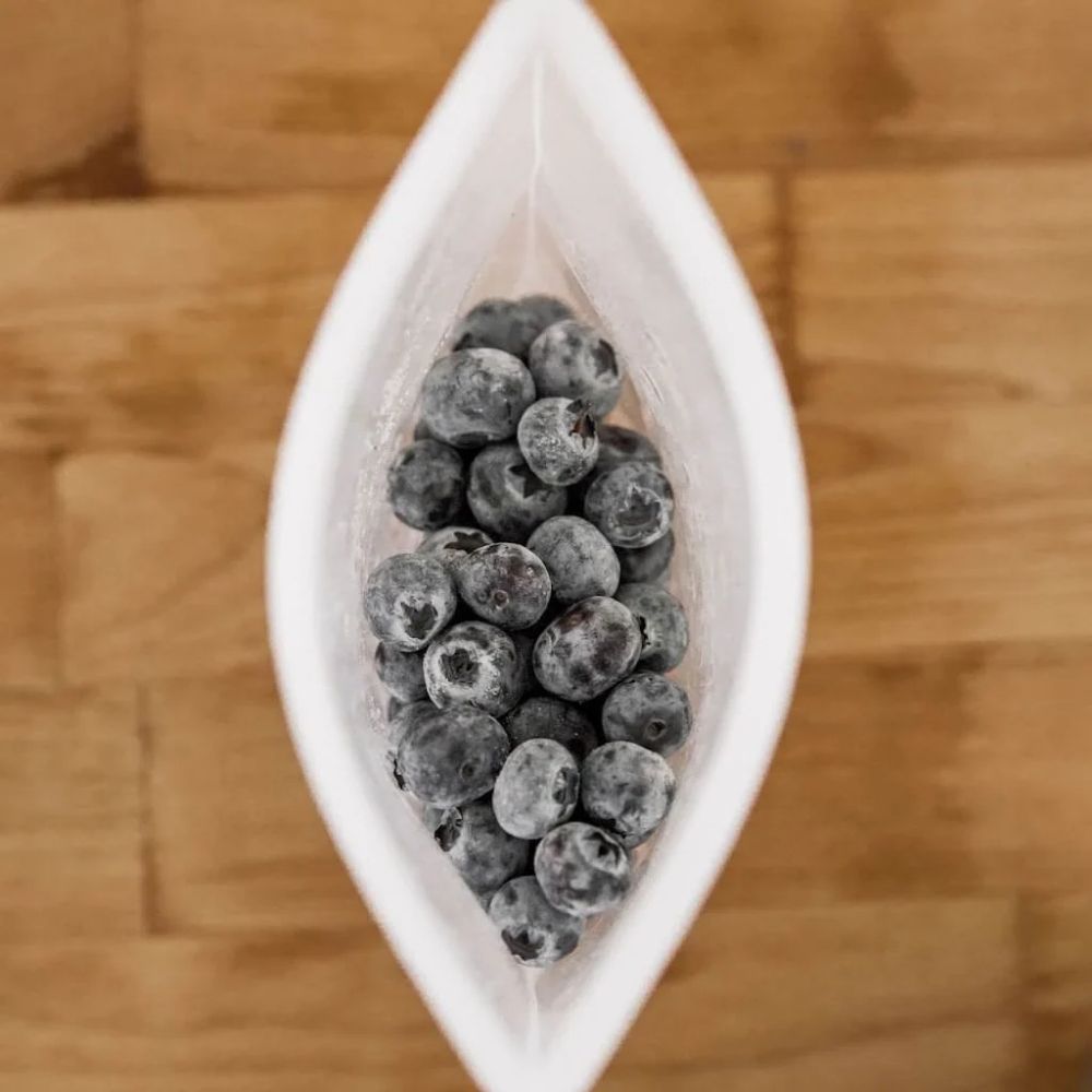 Liten gjenbrukbar silikonpose fra Seed & Sprout fylt med ferske bær – et bærekraftig og gjenbrukbart alternativ til engangsplast for trygg oppbevaring av mat.