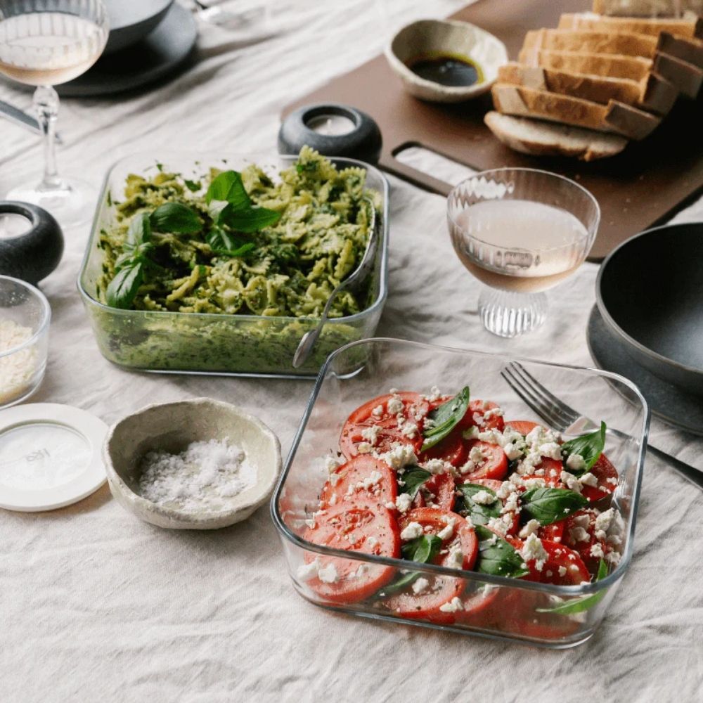 Firkantede glassbeholdere med glasslokk fra Seed and Sprout fylt med grønn pastasalat og tomatsalat, plassert på et dekket bord.