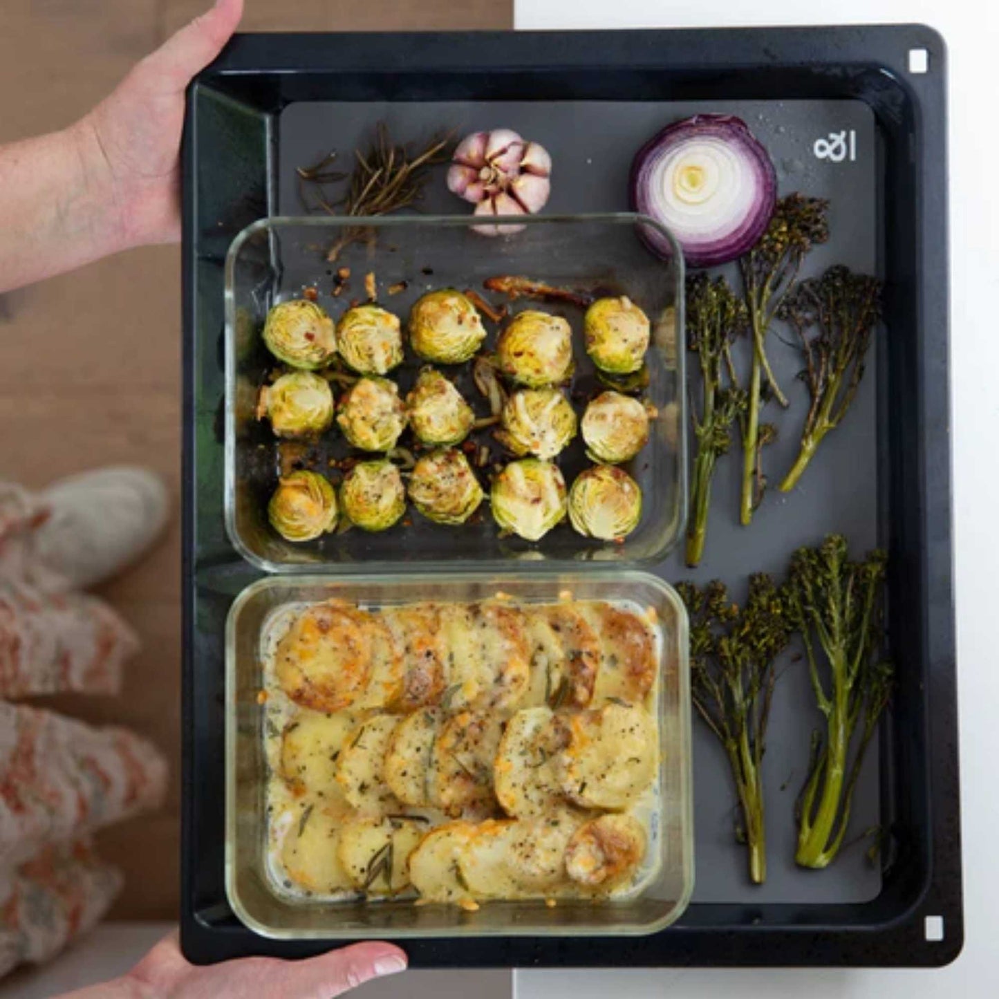 To glassbeholdere med mat plassert på en silikonbakematte i ovnen,