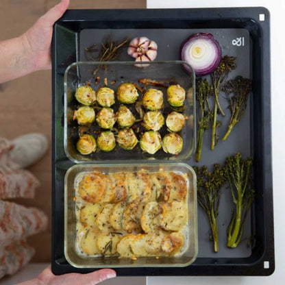 To glassbeholdere med mat plassert på en silikonbakematte i ovnen,