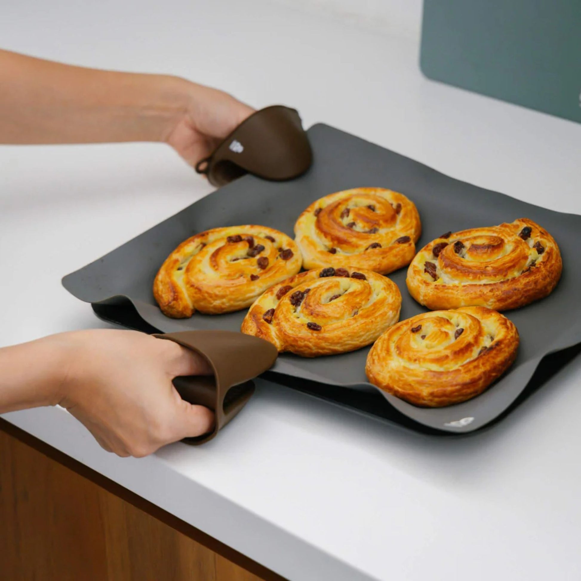 Grytevotter i LFGB-sertifisert silikon brukt til å løfte stekebrett med nystekte boller