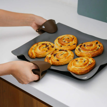 Grytevotter i LFGB-sertifisert silikon brukt til å løfte stekebrett med nystekte boller