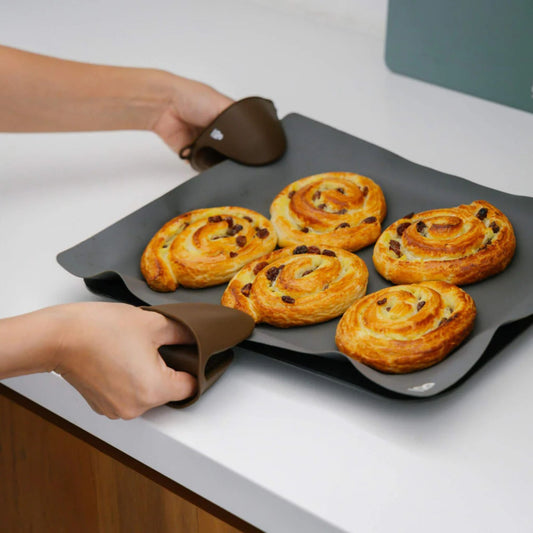 Grytevotter i LFGB-sertifisert silikon brukt til å løfte stekebrett med nystekte boller