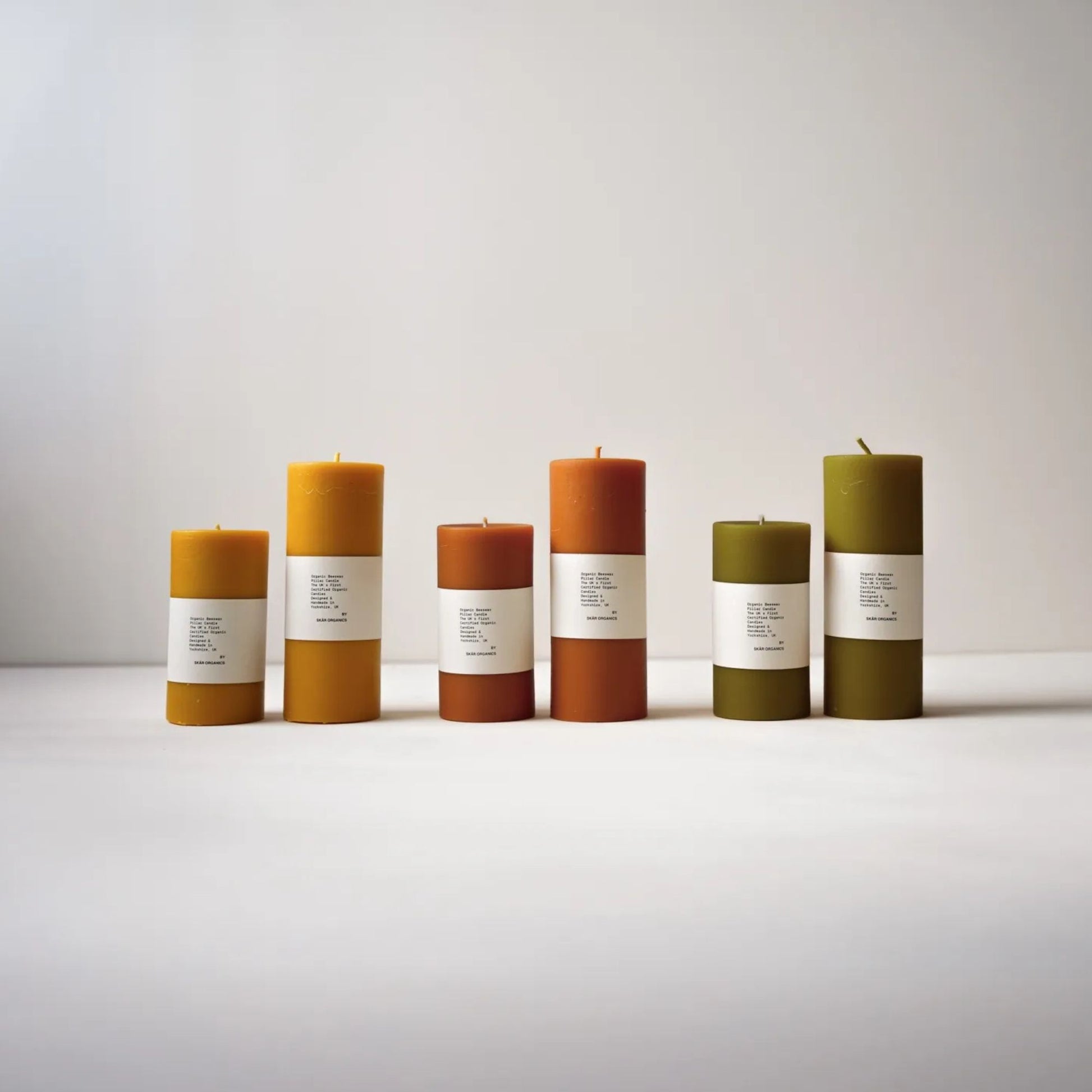 Tre kubbelys av økologisk bivoks i fargene naturlig gul, paprika og grønn te – håndstøpt med økologiske råvarer og naturlige plantepigmenter.