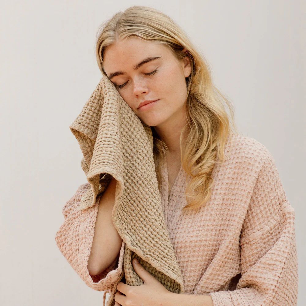 Jente med mykt beige MagicLinen ansiktshåndkle mot huden – naturlig, giftfritt og hudvennlig