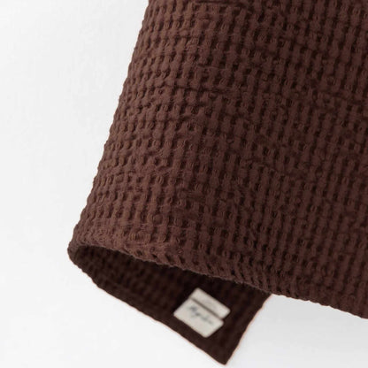 Detaljbilde av Dark Chocolate ansiktshåndkle i vaffelvevd lin og bomull fra MagicLinen, som viser den myke teksturen.