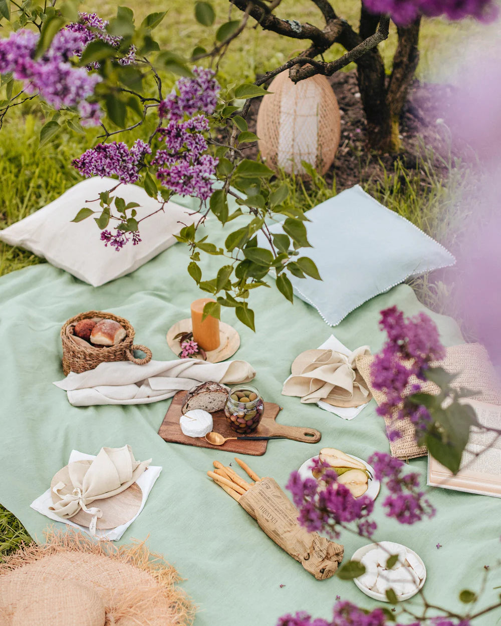Håndkle i lin og bomull fra MagicLinen lagt på gress under piknik i hage – naturlig og giftfritt valg