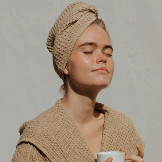 Kvinne med MagicLinen beige lin hårturban i vaffelstruktur, naturlig og plastfritt alternativ for skånsom tørking av hår.
