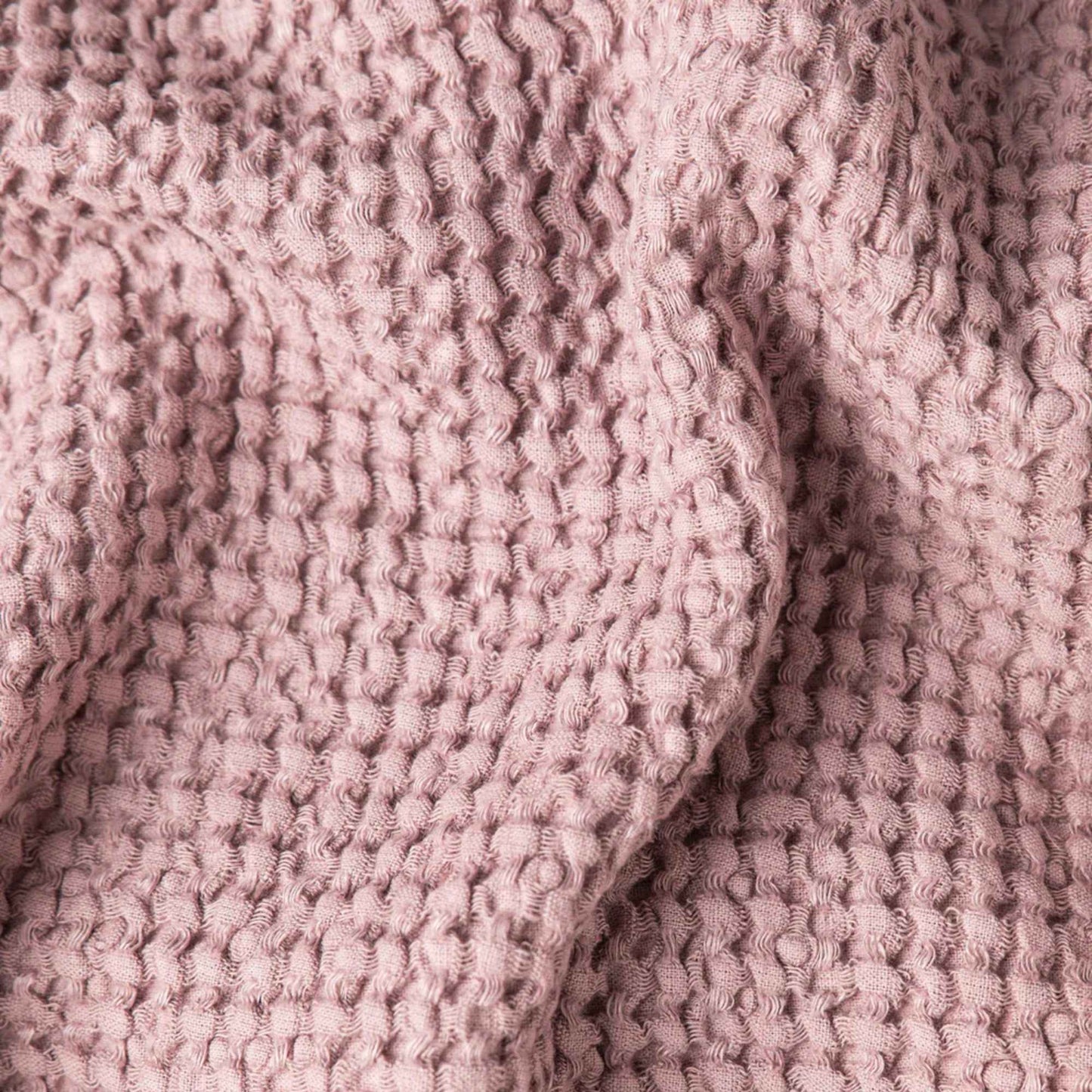 Nærbilde av waffle-teksturen på badematten i fargen Woodrose fra MagicLinen, med tydelig struktur og linblanding.