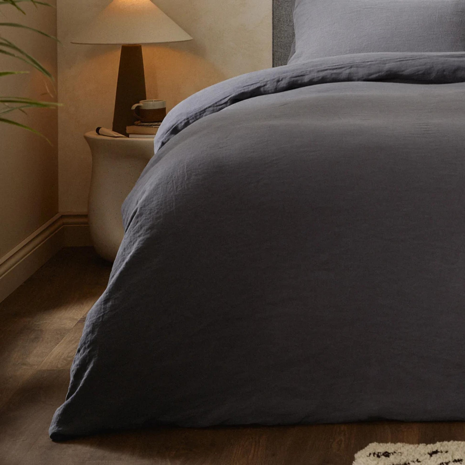Mariana sengesett i økologisk bomull og lin i fargen Charcoal, lagt på seng i naturlig soverom – pustende, allergivennlig og bærekraftig sengetøy fra Woolroom