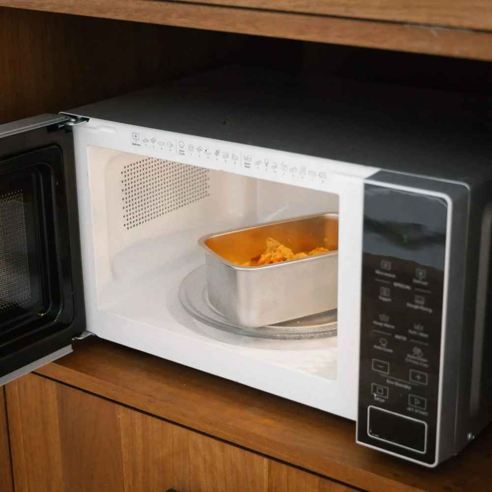 Matbeholder i rustfritt stål fra Seed & Sprout brukt til oppvarming av mat i mikrobølgeovn.