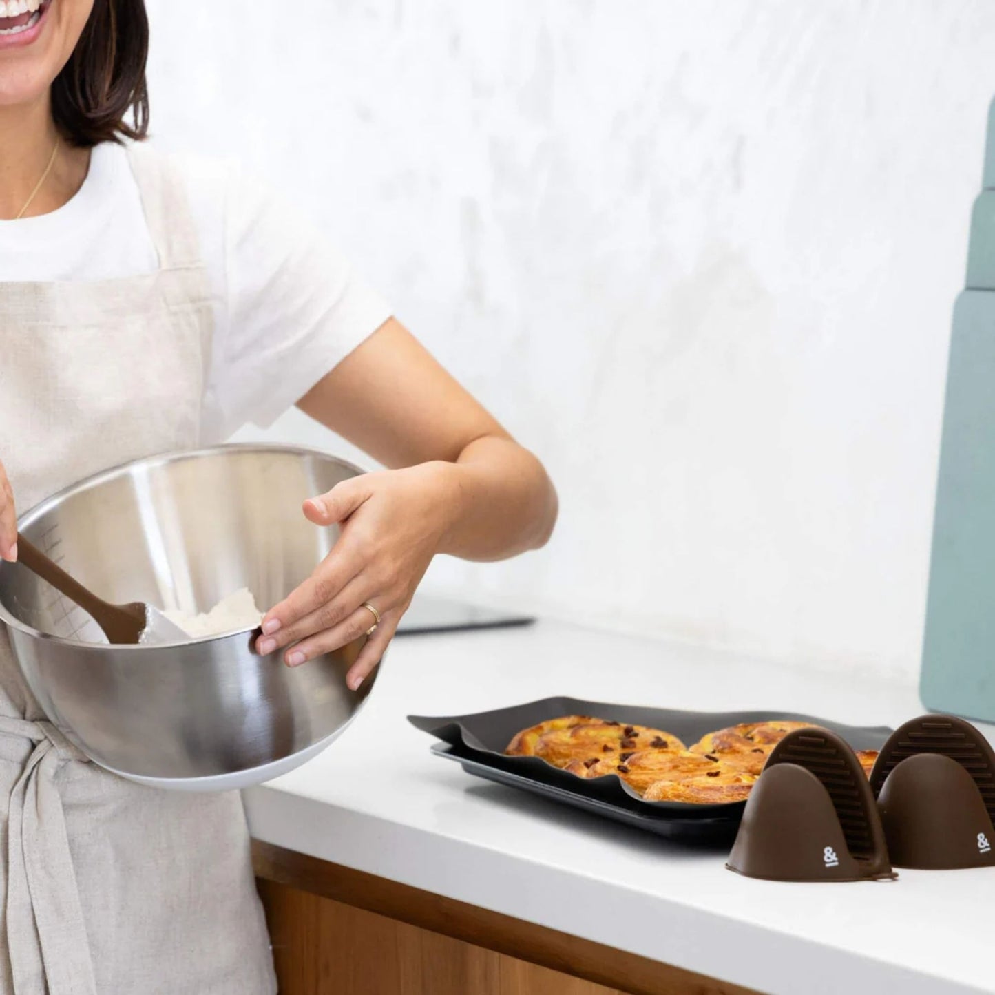 Miksebolle i rustfritt stål med glasslokk fra Seed & Sprout ved siden av silikonmatte og grytekluter – et plastfritt og bærekraftig kjøkkenvalg.