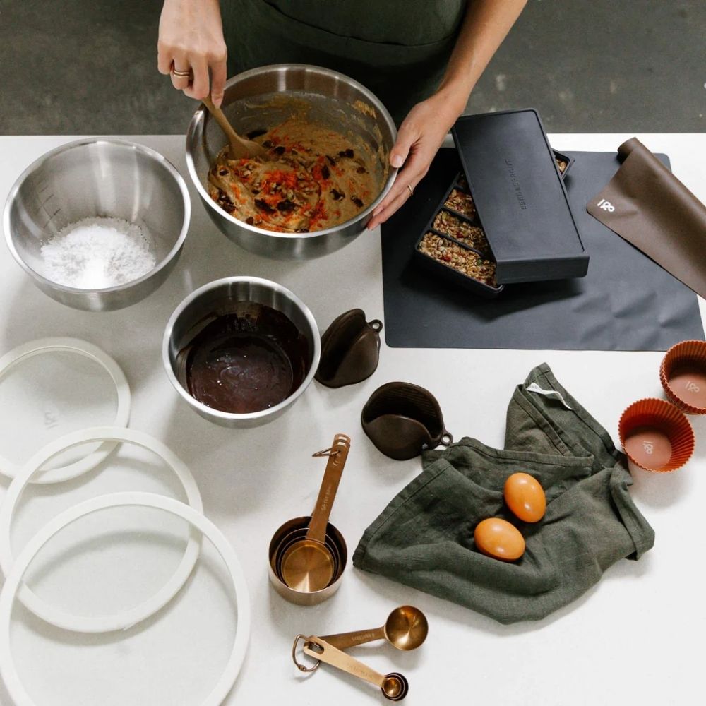 Tre mikseboller i rustfritt stål med glasslokk og silikonbase på en kjøkkenbenk under baking – et plastfritt og bærekraftig alternativ til vanlige boller i plast.