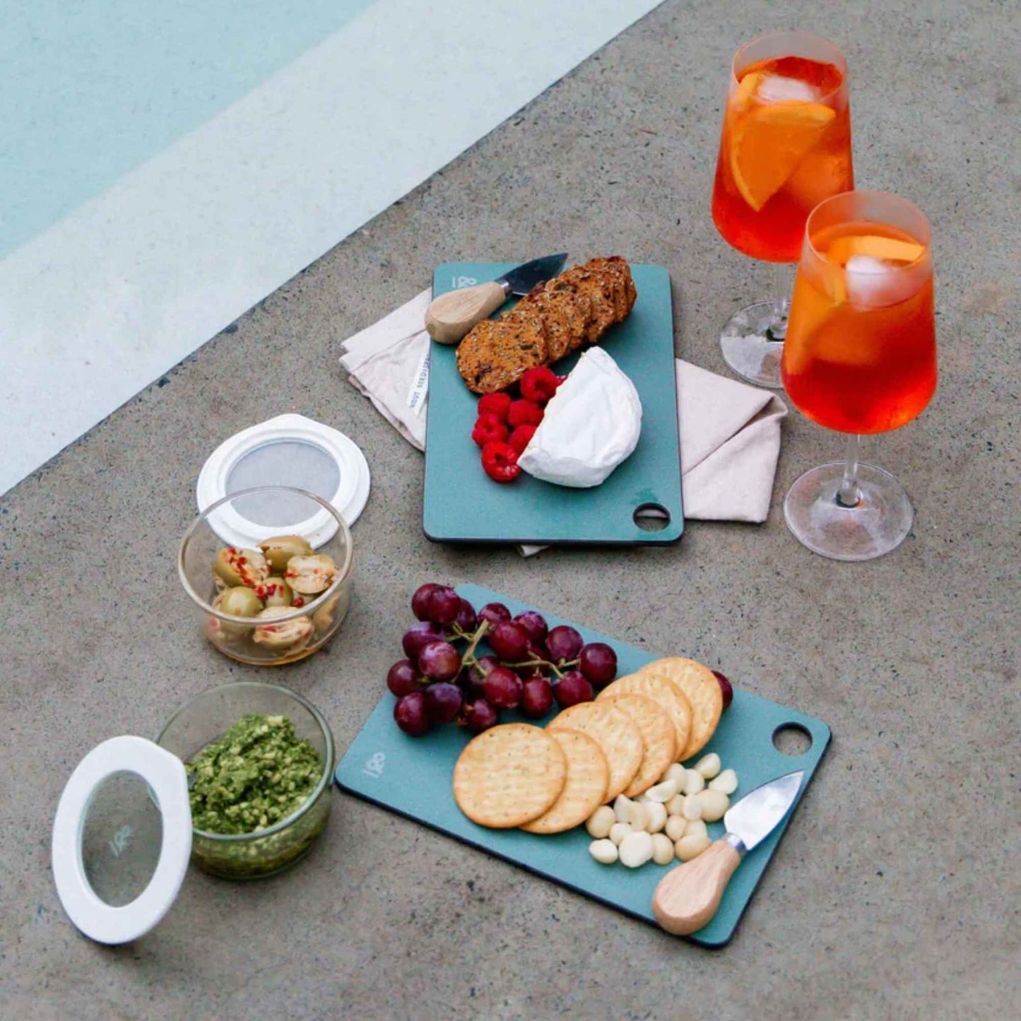 Mini skjærefjøler i fargen eucalyptus fra Seed & Sprout brukt til servering av kjeks, druer, ost og snacks ved basseng