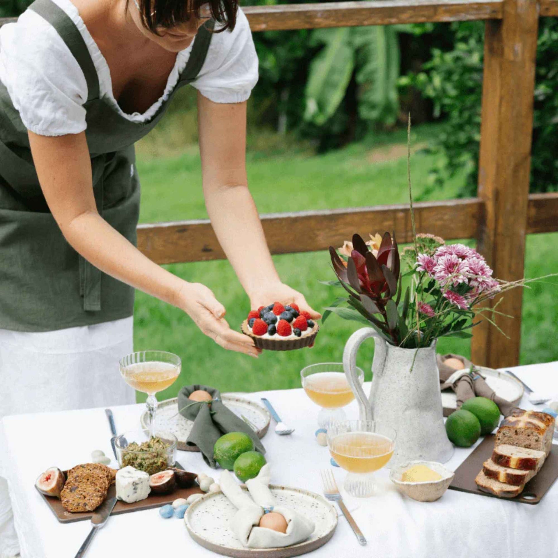 Mini Wood Fibre skjærefjøl i fargen Nutmeg brukt i en lys borddekking med brød, frukt og servering.
