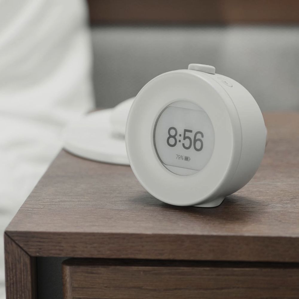 Lysegrå Mudita Harmony 2 vekkerklokke med E Ink-skjerm på nattbordet