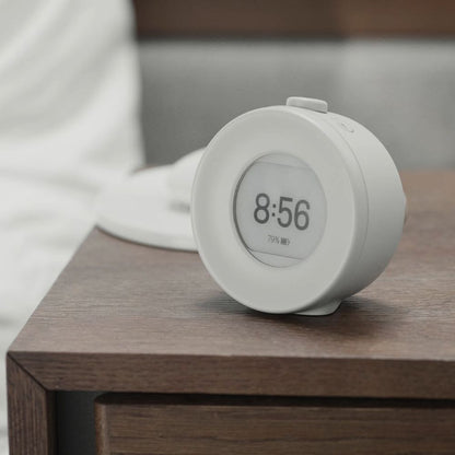 Lysegrå Mudita Harmony 2 vekkerklokke med E Ink-skjerm på nattbordet